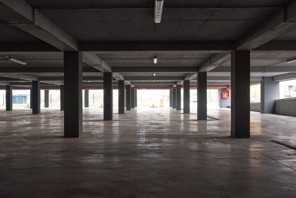 Empty underground parking lot or garage interior with concrete columns.